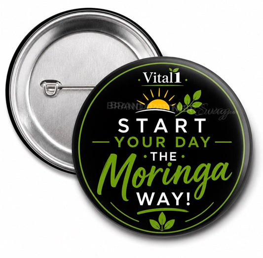 Front and back of a 3-inch Vital1 “Start Your Day the Moringa Way” conversation starter pin back button featuring a glossy black background, green botanical design, sunrise graphic, and silver metal pin backing.
