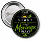 Front and back of a 3-inch Vital1 “Start Your Day the Moringa Way” conversation starter pin back button featuring a glossy black background, green botanical design, sunrise graphic, and silver metal pin backing.